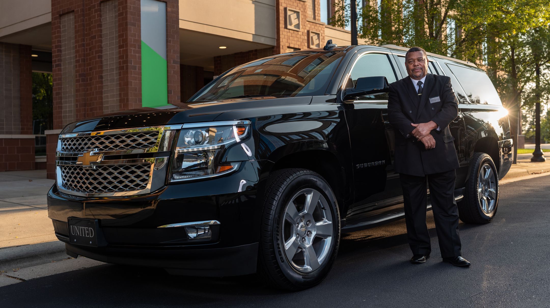 Chauffeur professionnel devant un SUV noir